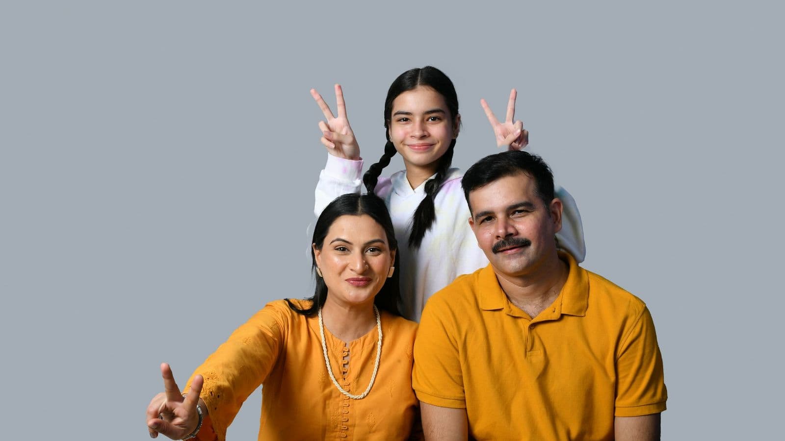 बगीचे में बैठा मुस्कुराता हुआ भारतीय परिवार